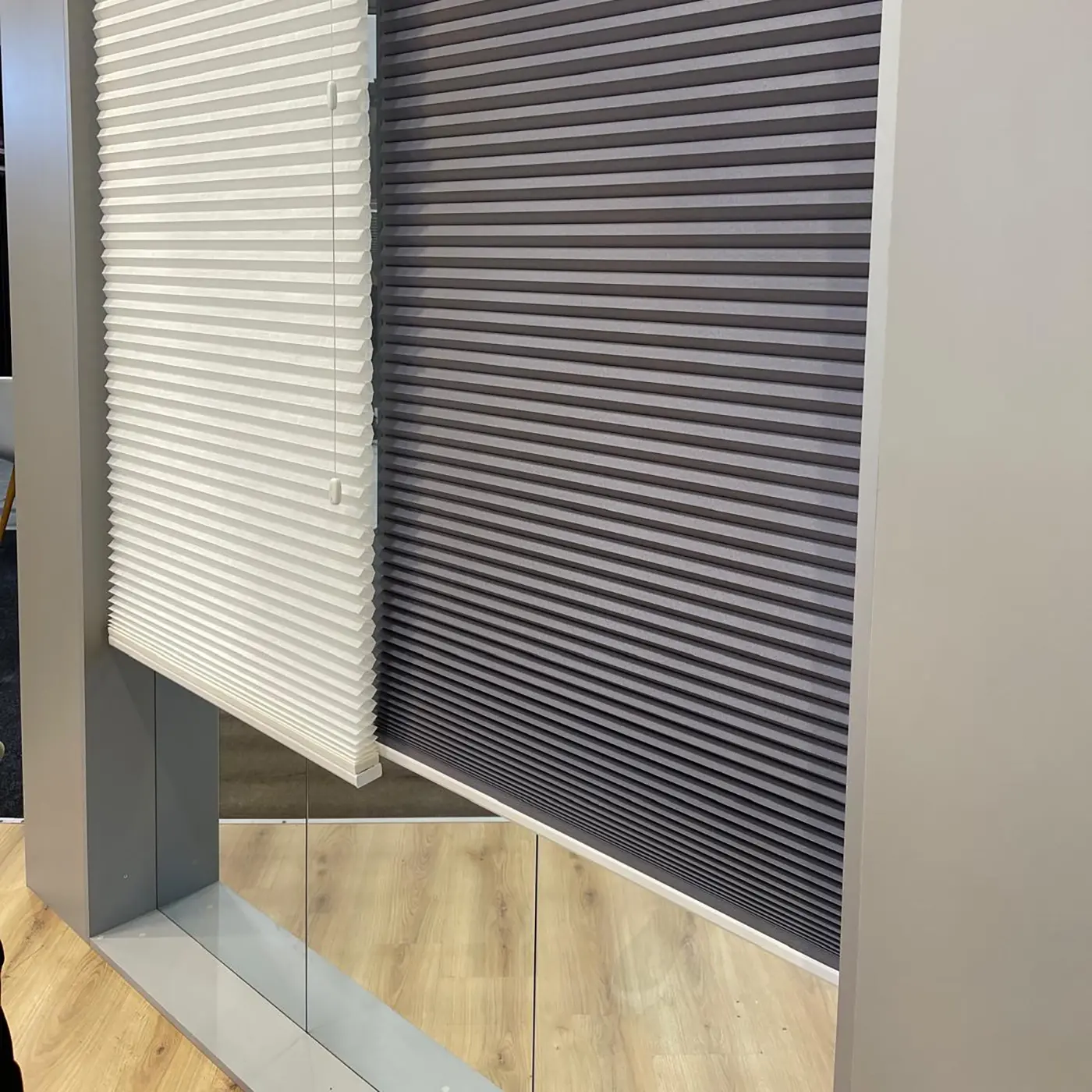 Plisségordijnen in wit en grijs in de showroom